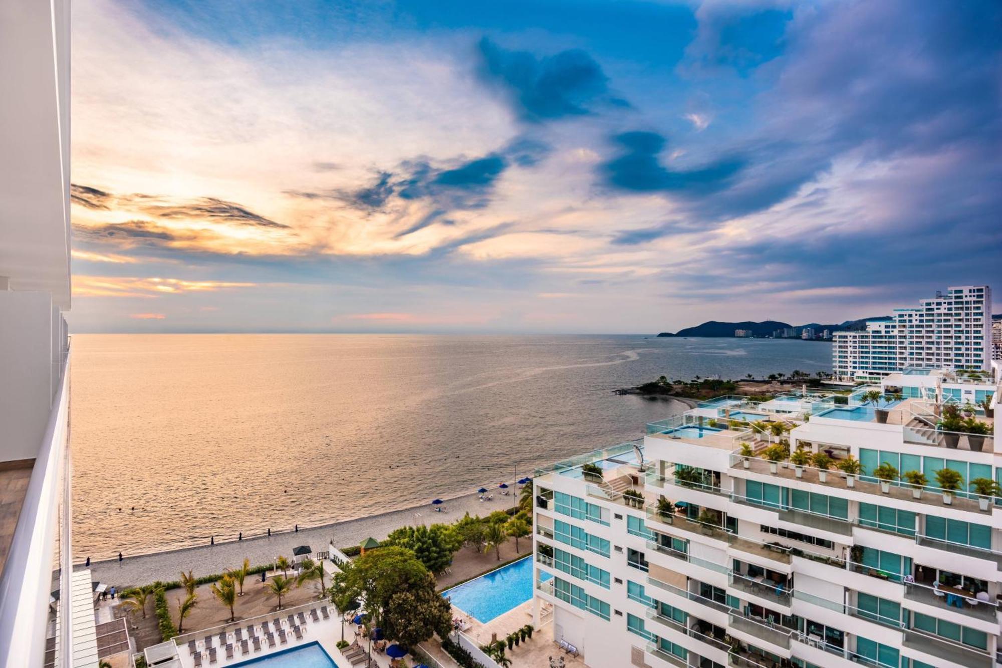 Suite Junior con una cama extragrande, sofá cama y vistas parciales al mar
